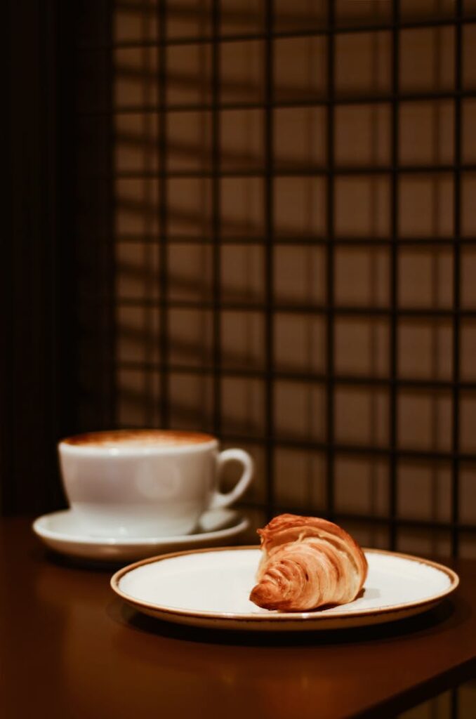 Warm morning coffee with flaky croissant in a cozy cafe setting. Perfect breakfast vibe.