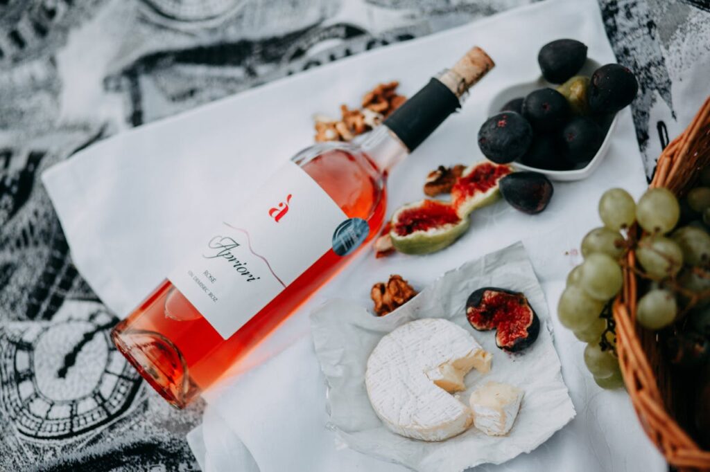 A stylish picnic scene with rosé wine, cheese, figs, and grapes, perfect for a luxurious outdoor celebration.